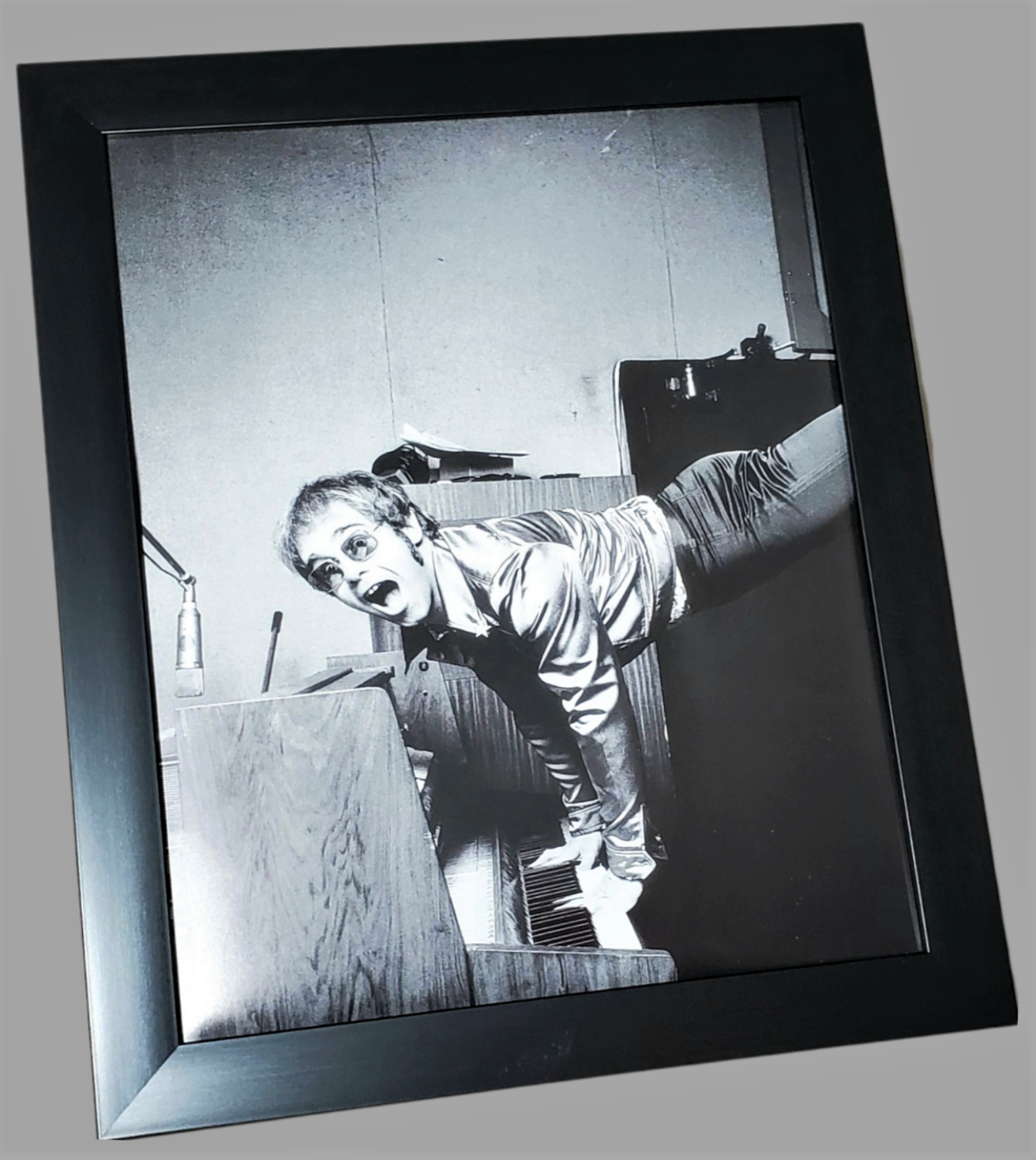 Authentic framed photograph page of Elton John performing a handstand on his piano in London, 1972 available in area51gallery