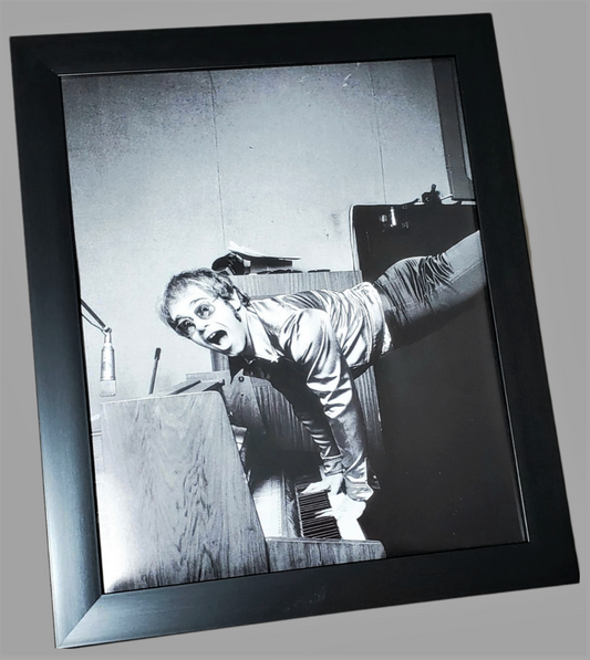 Authentic framed photograph page of Elton John performing a handstand on his piano in London, 1972 available in area51gallery